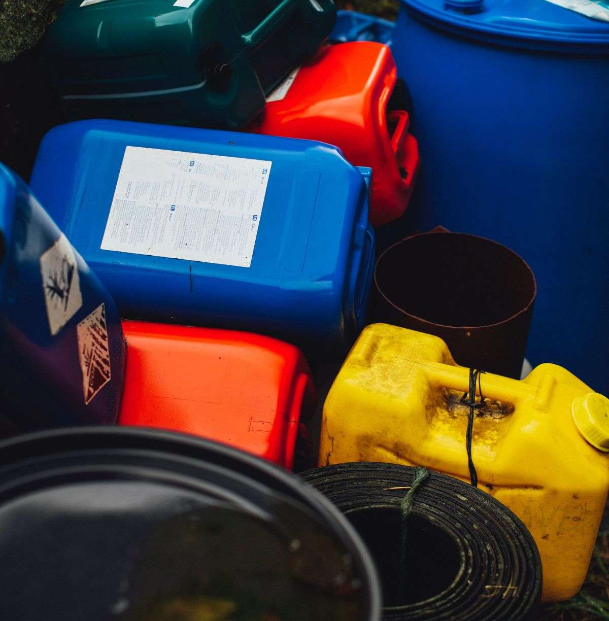 Gas and oil cans piled amidst other hazardous material