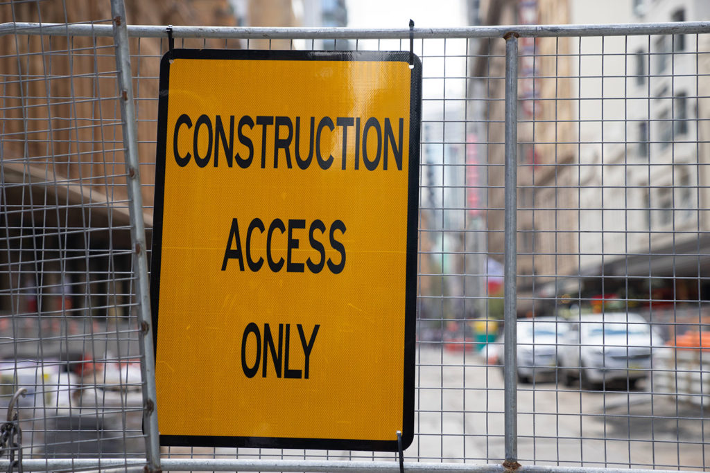 Temporary fencing for a construction site with a yellow sign that reads 'Construction Access Only'