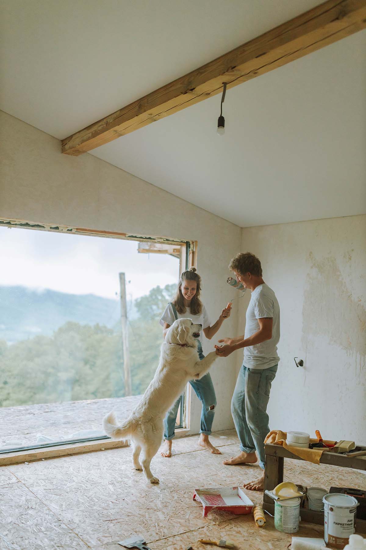 Couple and their dog standing among their active renovation zone.